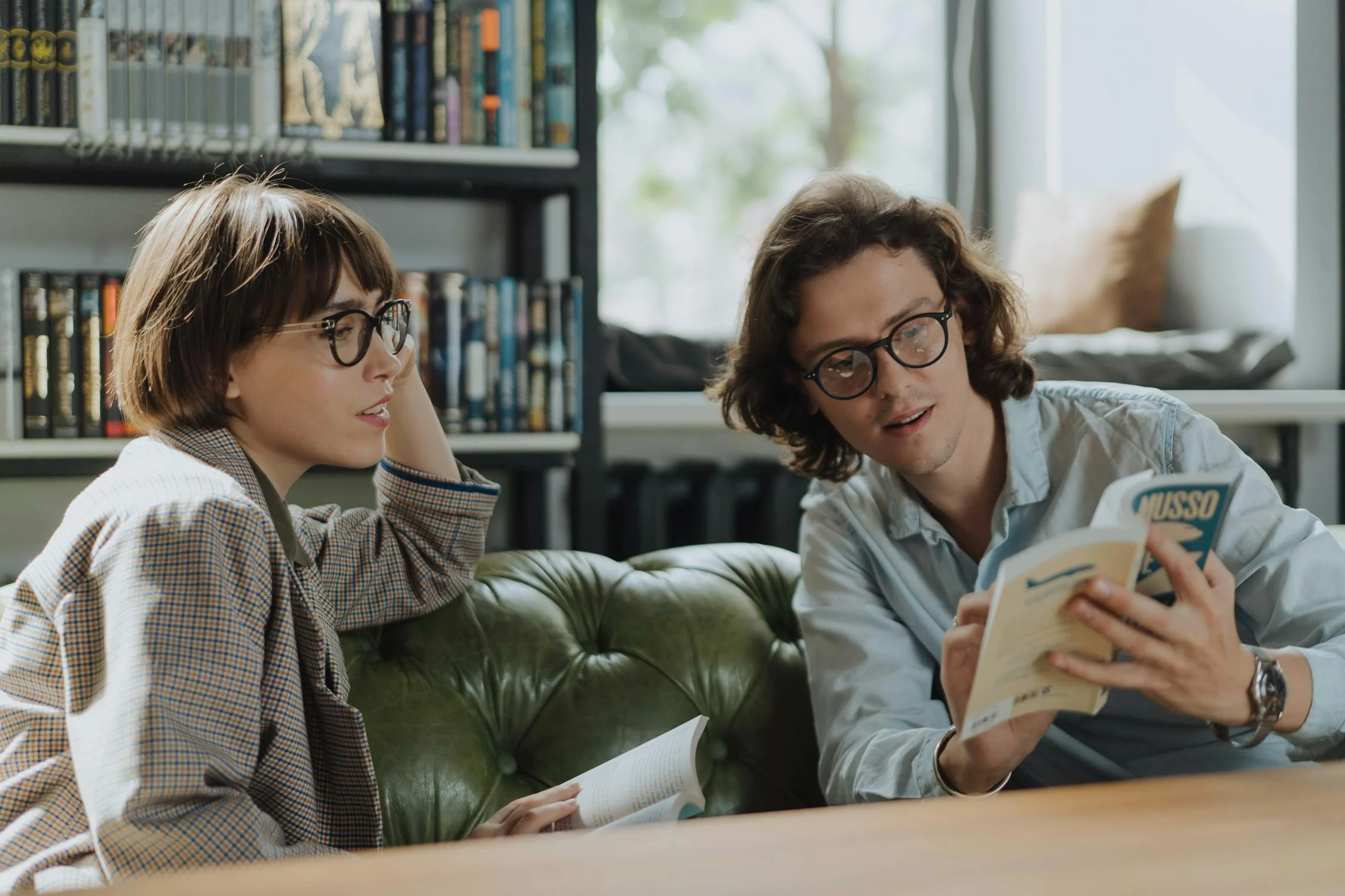 A man showing a woman something from inside a book.